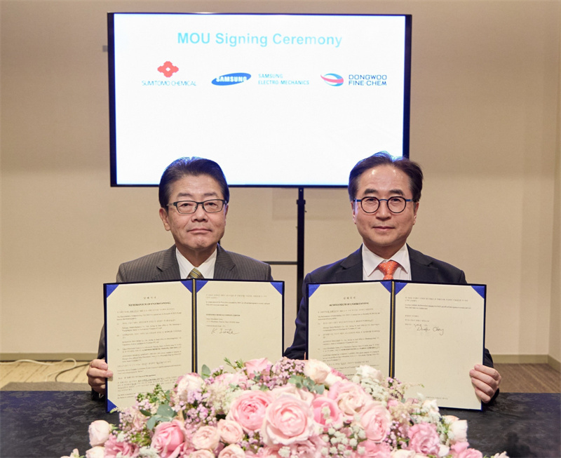 Sumitomo Chemical Chairman Keiichi Iwata (left) and Samsung Electro-Mechanics President Duckhyun Chang sign an MOU. Sumitomo Chemical Chairman Keiichi Iwata (left) and Samsung Electro-Mechanics President Duckhyun Chang sign an MOU.